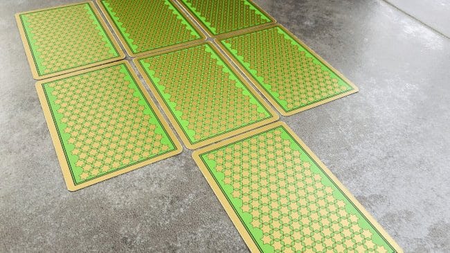 Tirage à 7 cartes du Tarot Persan Indira disposées en 3 colonnes thématiques sur une surface.