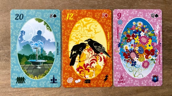 3 cartes du Petit Lenormand Esmeralda alignés sur une table de consultation.