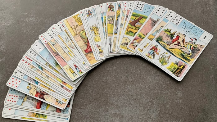 Boîte et cartes du Grand Jeu de Mademoiselle Lenormand disposées sur une table.