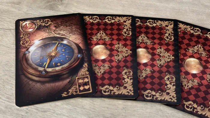Carte La Boussole 42 Gilded Lenormand indiquant une direction lors d'un étalement linéaire de trois cartes.
