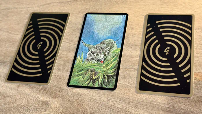 Un lynx caché dans des herbes, illustration de la carte 57 de l'Oracle Gé : Le Lynx.